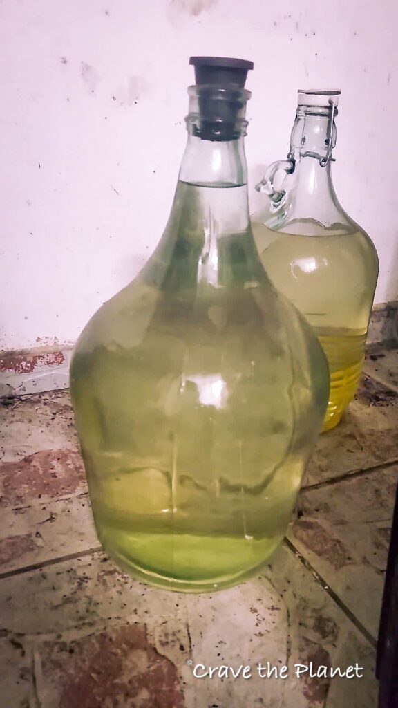 homemade palinka bottles on floor in basement in romania