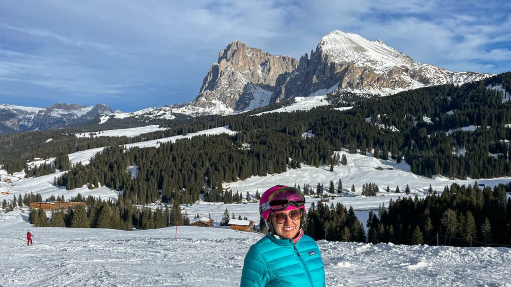 woman skiing in dolomites with pink hat and blue coat. best ski boot dryers