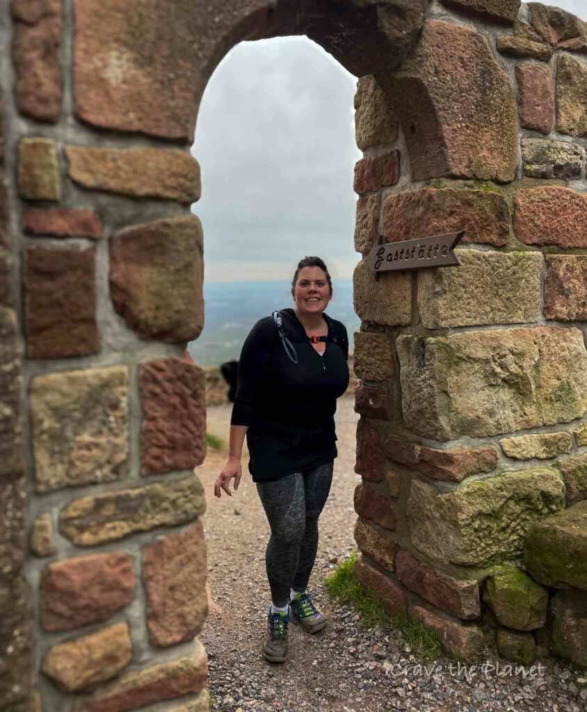 woman hiking in rietburg castle restaurant through sandstone door