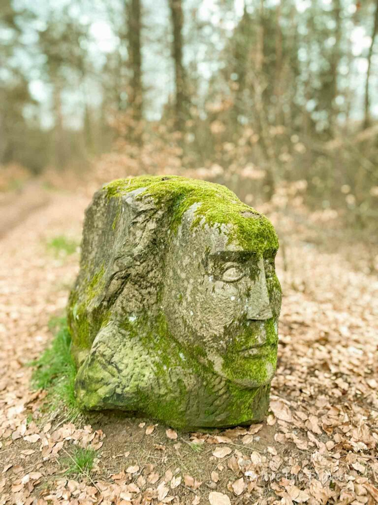 stone statue in forest with moss