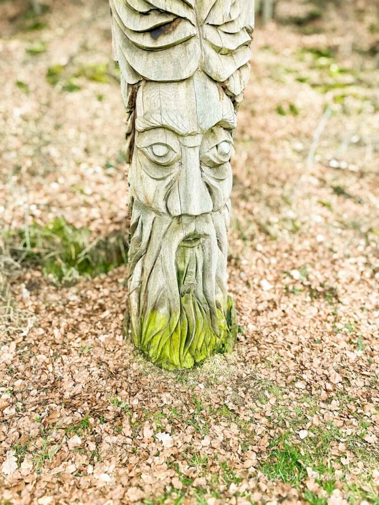 wood statue in forest with moss